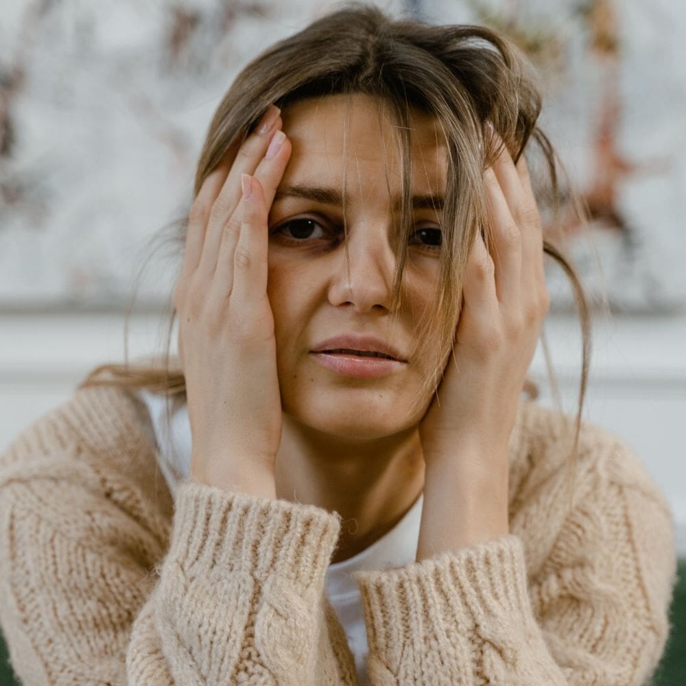 Stressed woman holding head with both hands
