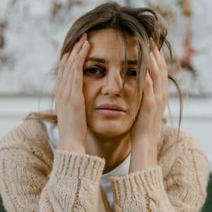 Stressed woman holding head with both hands