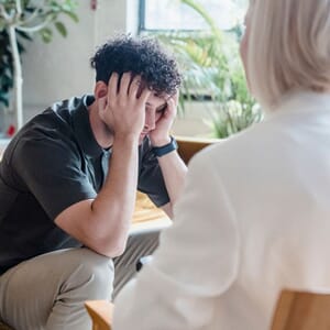 Man holding head during therapy session