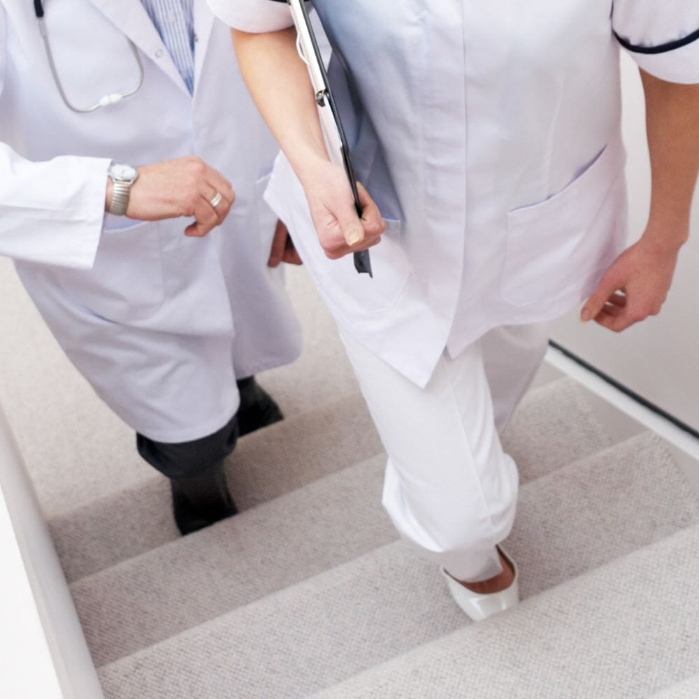 Two doctors in white coats climbing stairs