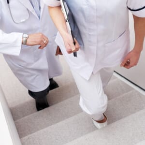 Two doctors in white coats climbing stairs
