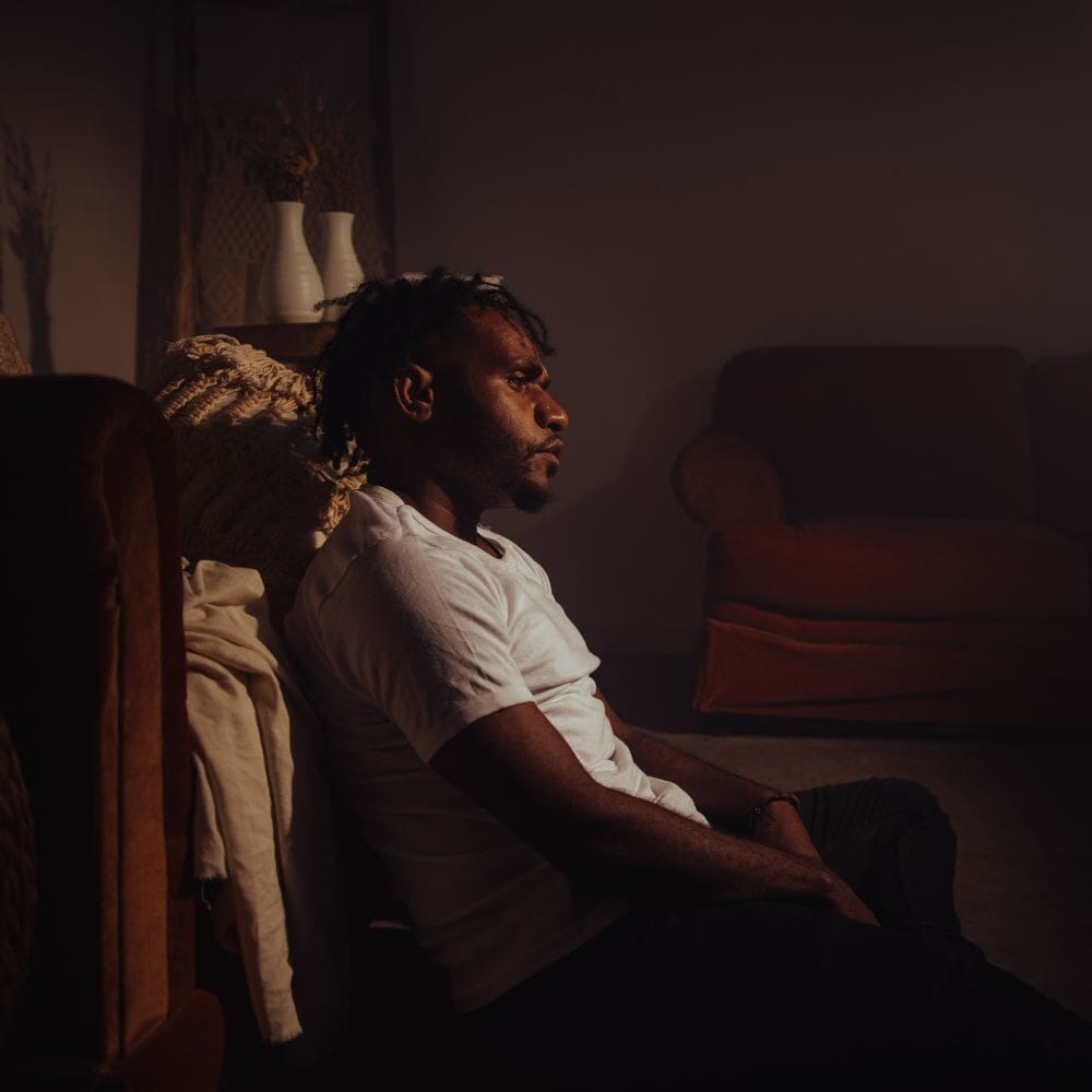 Man sitting on floor looking emotionally drained