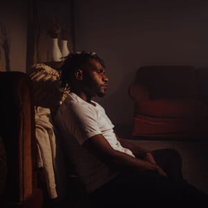 Man sitting on floor looking emotionally drained