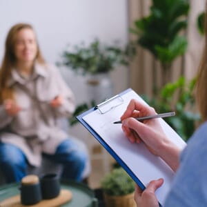 Therapist taking notes during patient conversation
