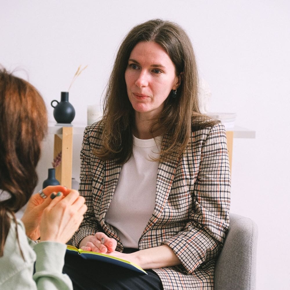 A female therapist attentively listens to a patient