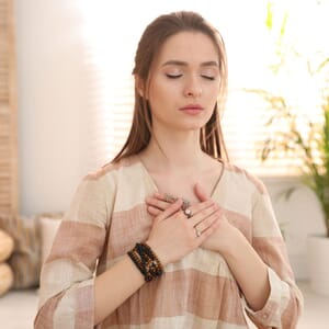 A calm woman with her hands on her chest