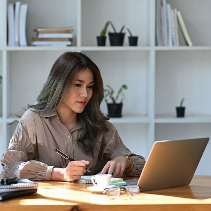 A female therapist looks on a laptop while working.
