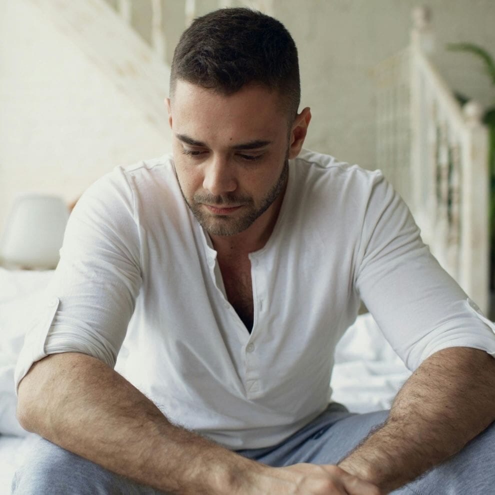 Man sitting alone showing signs of depression and emotional distress.
